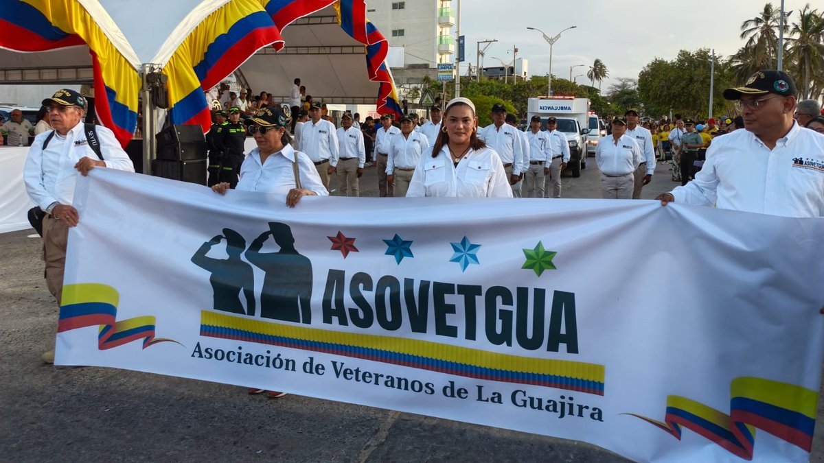 Asociados de ASOVETGUA con la pancarta de la asociación en el desfile del 20 de julio en Riohacha